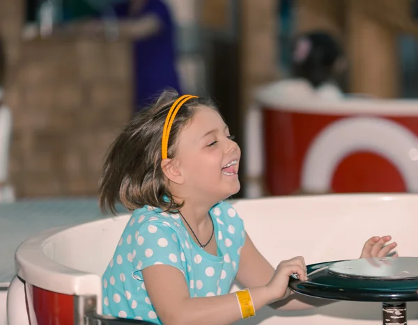 Радостная маленькая девочка наслаждается катанием на карусели — стоковое фото