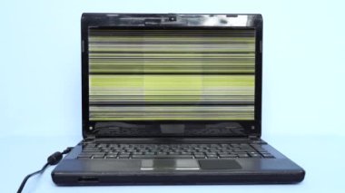 An old laptop with faulty display. Problems working on an outdated laptop. Threat of sudden breakdown and loss of unsaved information. Horizontal colored lines on faulty monitor display. 4K video