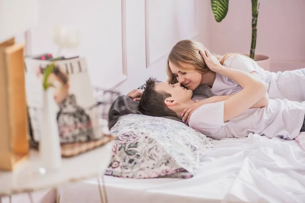 Genç ve çekici romantik çiftin yakın portresi. Sarılma ve öpüşme, yatağa uzanma, birbirini sevme. Aşk ve ilişkiler yaşam tarzı, iç yatak odası..