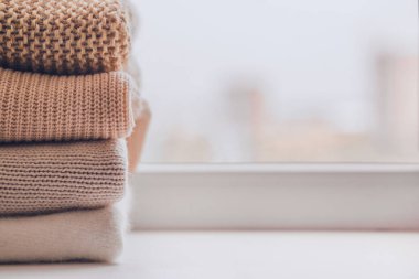 Pencere perdelerinde sıcak örülmüş süveter yığını..