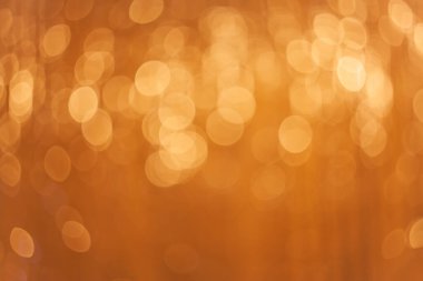 Bokeh arka planı aydınlatıyor. Soyut altın renkli ışık. Noel konsepti.