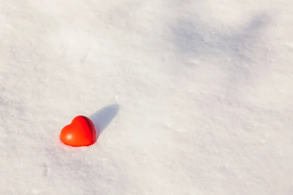 在阳光明媚的冬日黄昏 橡胶抗压玩具的红心躺在雪盖上 心胸狭窄的小雪背景 复制空间 — 图库照片