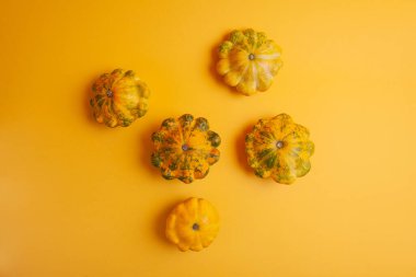 Patissons or squash scattered on a yellow background.