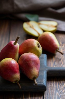 Tahta bir masada olgun kırmızı armutlar. Kapat..