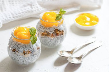 Hindistancevizi sütlü Chia Pudingi, mango, chia tohumu, bardakta granola. Sağlıklı beslenme, sağlıklı yaşam tarzı, diyet, fitness menüsü kavramı. 