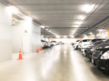 Otoparktaki birçok arabanın soyut bulanık görüntüsü. Mağaza veya alışveriş merkezinin içi, arka plan için sanayi binası.
