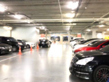 Otoparktaki birçok arabanın soyut bulanık görüntüsü. Mağaza veya alışveriş merkezinin içi, arka plan için sanayi binası.