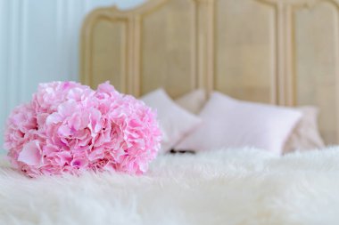 Yatağın üzerine pembe bir çiçek buketi konur..