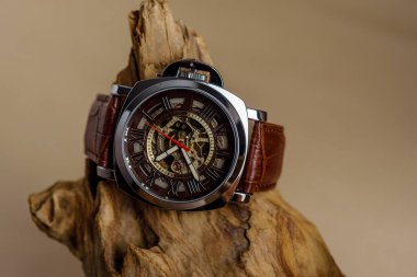 Kahverengi arka plandaki keresteye yerleştirilmiş lüks erkek kol saatlerini kapatın.