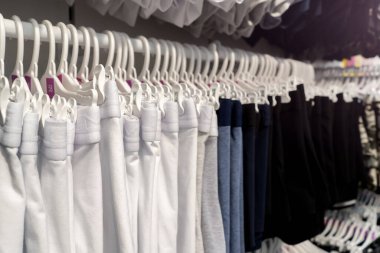 Renkli bir arka planda gardırop rafında asılı şık kıyafetler.