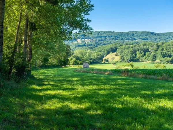 Güneybatı Fransa 'da St. James Yolu' nda arka planda tepe olan bir tarlada güneşli bir yaz öğleden sonra Lot Nehri Vadisi 'nde hiç insan olmadan alındı.