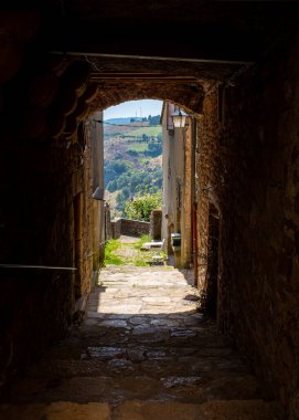 A passageway leading to the countryside in a small Southern France town (Barre-des-Cevennes), taken on a sunny summer morning with unrecognizable people
