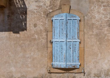 A pale blue window on an historical house in the Southern France town of Joyeuse, Ardeche, taken on a sunny summer morning with no people