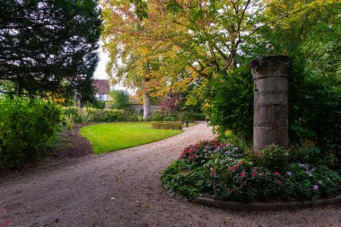 Provins, France - October 17, 2021: A gravel path in a french public park with autumn foliage. Taken on a partly sunny autumn afternoon
