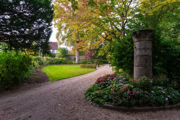 Provins, France - October 17, 2021: A gravel path in a french public park with autumn foliage. Taken on a partly sunny autumn afternoon