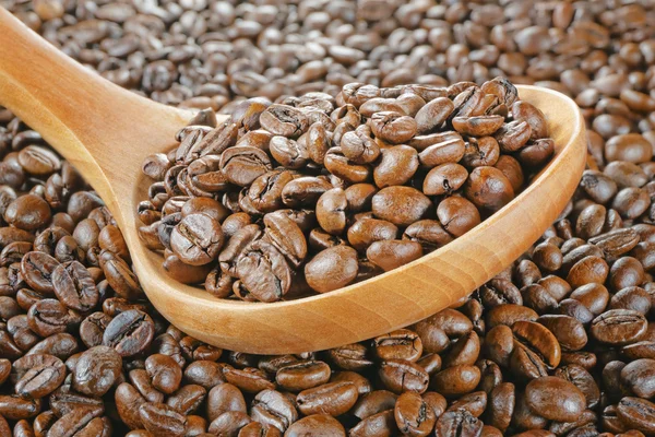 Träsked kaffebönor — Stockfoto