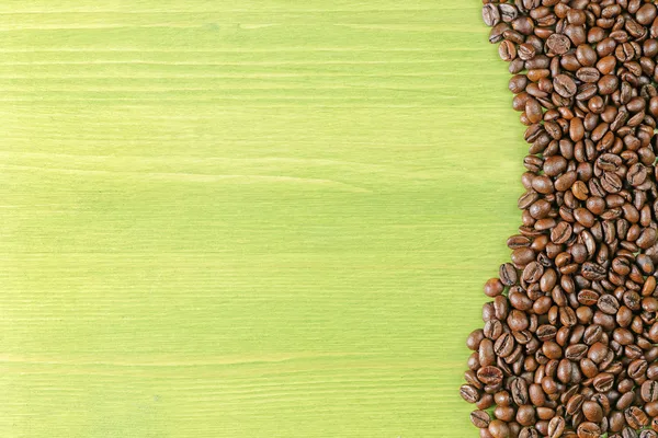 Kaffebönor gröna bordet — Stockfoto