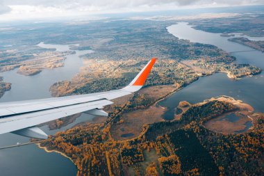 Uçak penceresinden kanada ve sonbahar sarı ormanına kadar uzanan hava manzarası.