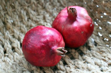Jüt sepetinde iki olgun nar. Sulu kırmızı meyveler. 