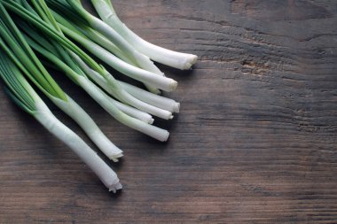 Yeşil soğan, ahşap zemin üzerinde tekstil. Eski ahşap üzerinde soğan. Taze soğan. Yeşil soğan (Gıda ve Sağlık Konsepti). Bir demet taze soğan.