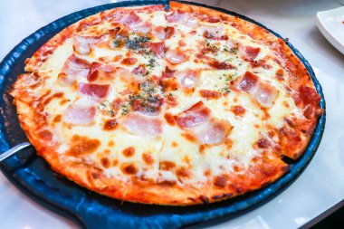 Yakın plan mozzarella peynirli ve pastırmalı ev yapımı pizza.