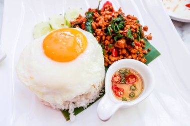 Üzerine kızarmış domuz eti, fesleğen ve sahanda yumurta.