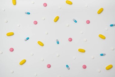 Kapsüllerdeki uyuşturucuların çeşitliliği ve beyaz arka plandaki farklı renklerdeki haplar