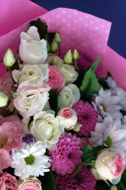 Gül ve kasımpatı ile süslenmiş pembe kağıtlı zarif bir buket. Anneme doğum günü ya da doğum günü için tebrikler. Güzel bahar çiçekleri.