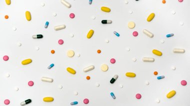 Kapsüllerdeki uyuşturucuların çeşitliliği ve beyaz arka plandaki farklı renklerdeki haplar