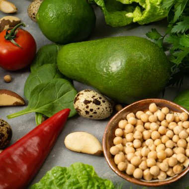 Sağlıklı beslenmek için avokado, nohut, fındık ve otlu taze sağlıklı sebzeler. Lifli ve sebze proteinleriyle dengeli bir diyet.