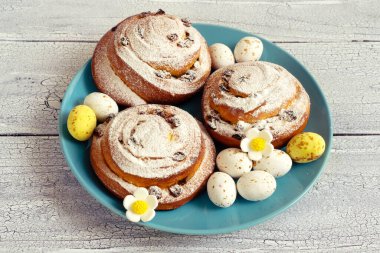 Paskalya yumurtası ve dekoru taze çörekler ve beyaz şekerli spiraller..