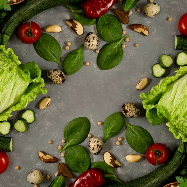 Diet plan with greens and fresh vegetables in a paper notebook on a gray table surface.