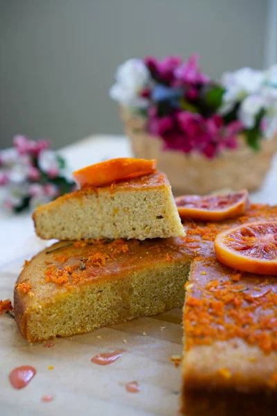 Ciasto Skórką Pomarańczy Ciemnym Naczyniu Pieczenia Stole Wiosennymi Kwiatami Ciastka — Zdjęcie stockowe