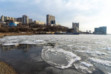 Buz, Amur Körfezi 'ni kışın şehrin arka planına karşı kapladı, Vladivostok, Primorsky Krai, Rusya.