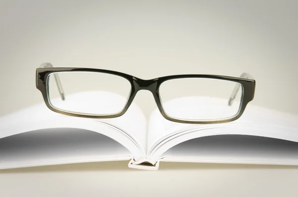 Brille auf weißem Buch — Stockfoto