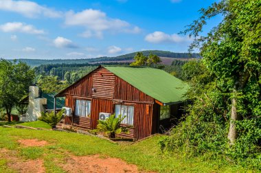 Sabie Güney Afrika 'da yerel çam ormanlarına ve yeşil bahçeye bakan güzel bir ahşap kulübe.