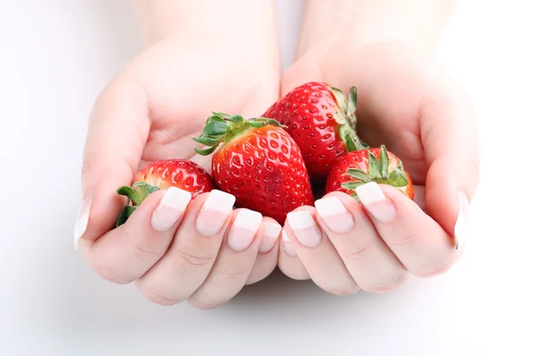 Fresh strawberries in hands against white background