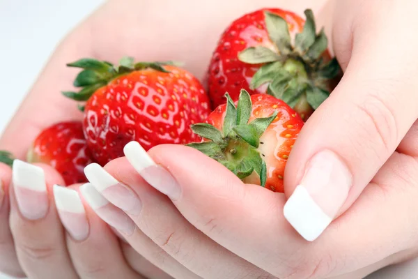 Verse aardbeien in handen tegen witte achtergrond — Stockfoto