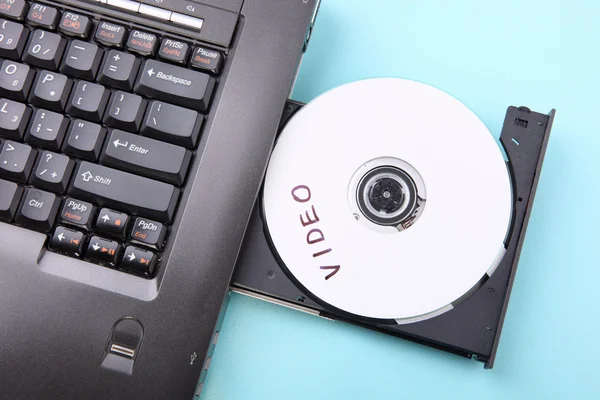 Image rapprochée d'un ordinateur portable et d'un disque CD ou DVD — Photo