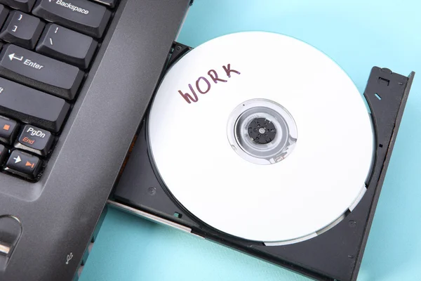 Immagine ravvicinata di un computer portatile e di un disco CD o DVD — Foto Stock