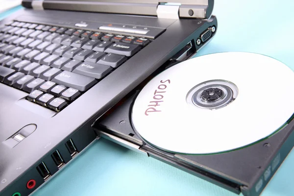 Image rapprochée d'un ordinateur portable et d'un disque CD ou DVD — Photo