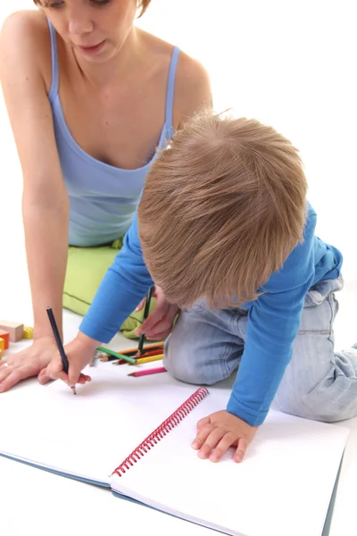 Mor lærer sønnen å tegne. – stockfoto