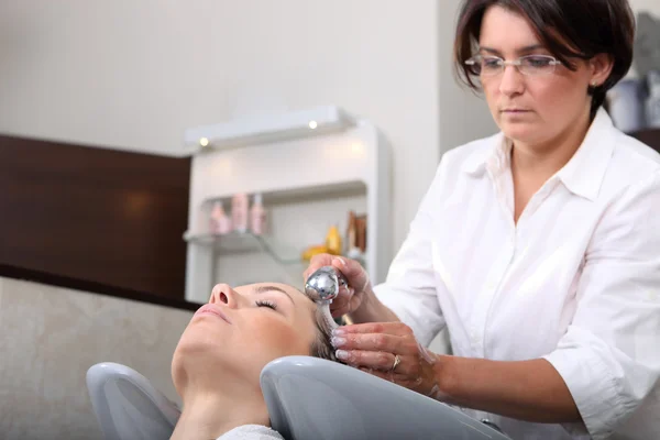 Schöne junge Mädchen genießen Haarwäsche im Friseursalon — Stockfoto