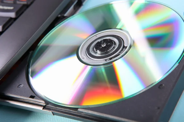 Image rapprochée d'un ordinateur portable et d'un disque CD ou DVD — Photo