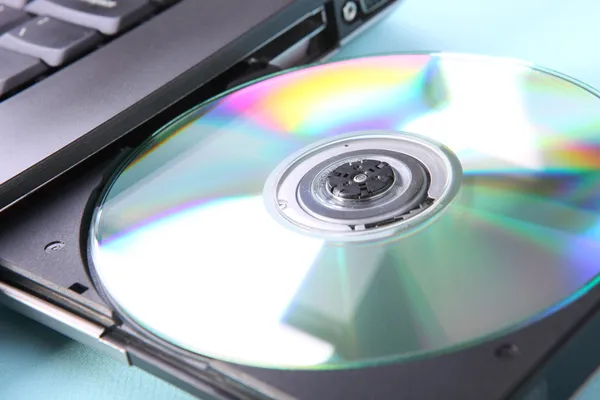 Closeup image of a laptop and a CD or DVD disc — Stock Photo, Image