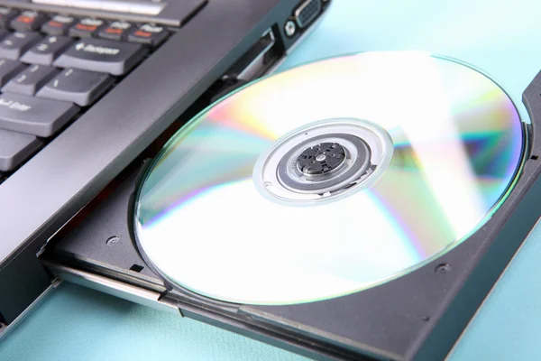 Imagen de primer plano de un ordenador portátil y un disco CD o DVD — Foto de Stock