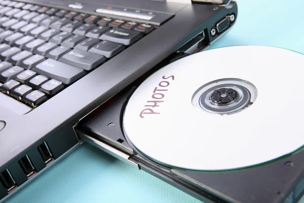 Image rapprochée d'un ordinateur portable et d'un disque CD ou DVD — Photo