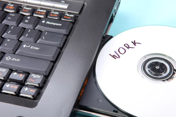 Immagine ravvicinata di un computer portatile e di un disco CD o DVD — Foto Stock