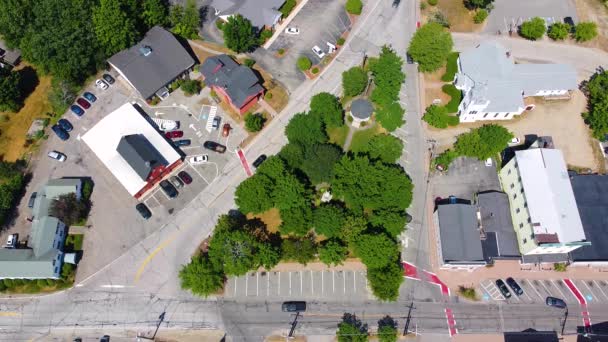 タウンホール ライマン記念公園 会衆派教会 レイモンド ニューハンプシャー 米国を含むレイモンドの町の中心部のトップビュー — ストック動画