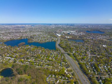 ABD 'nin Massachusetts MA, Arlington kentinin arka planında Spy Pond ve Boston modern şehir siluetinin yer aldığı Arlington Heights banliyö manzarası. 